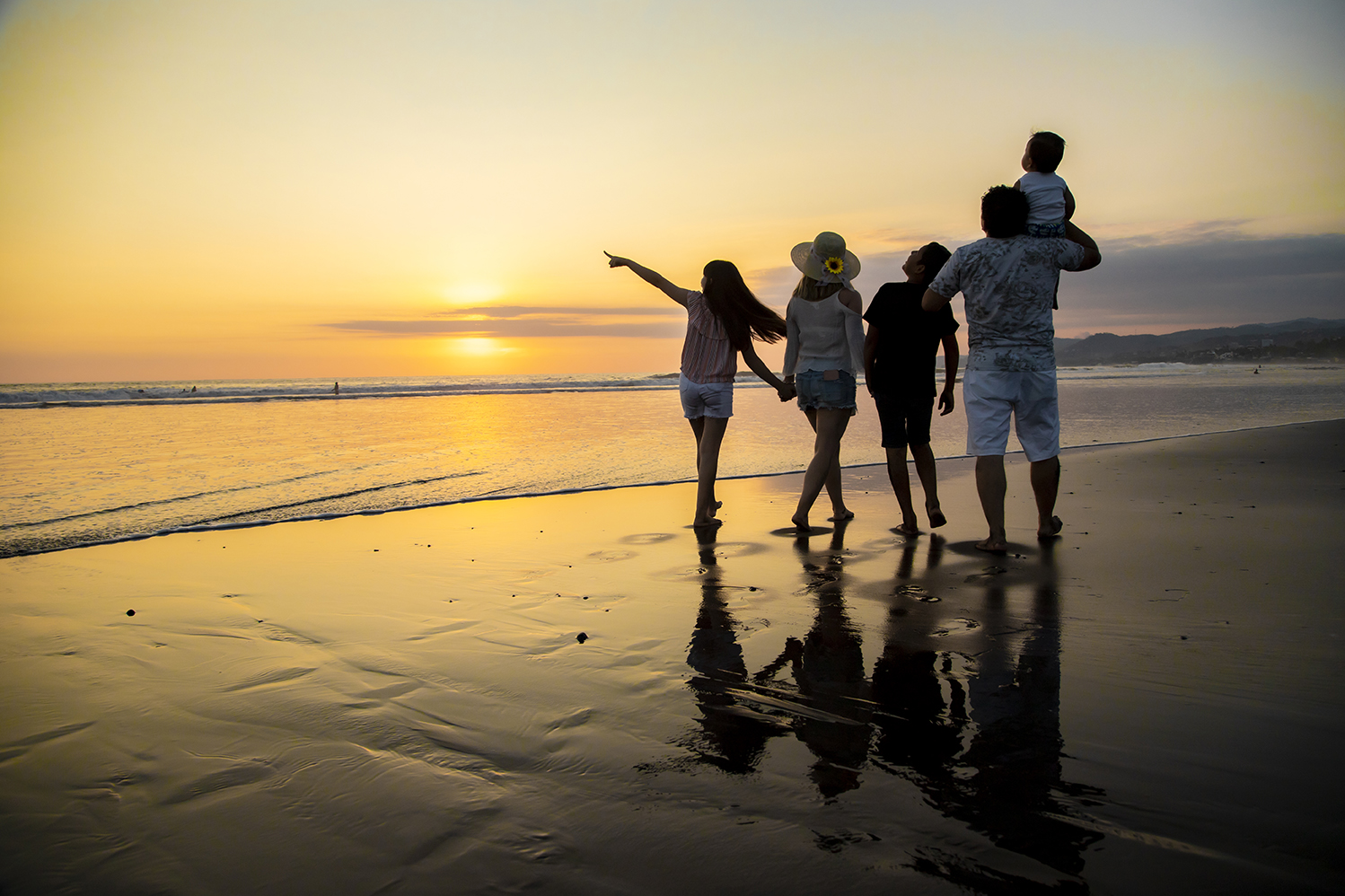 Familia disfrutando del atardecer en una playa de El Salvador